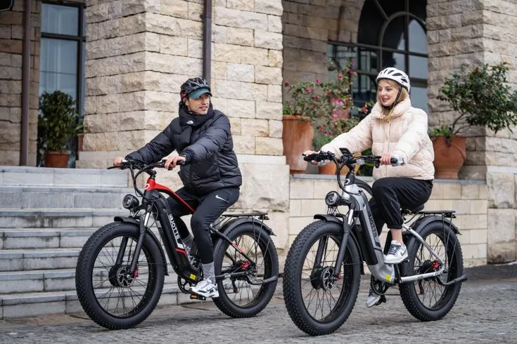 A man and a woman riding N26 and F26 Duotts electric bicycles in the town